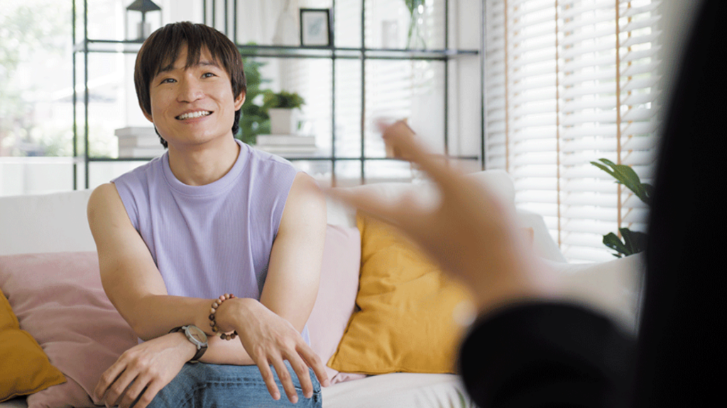 A queer person happily attending a therapy session while in detox