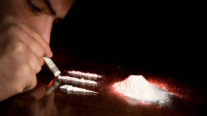 A gay masculine looking man snorting cocaine