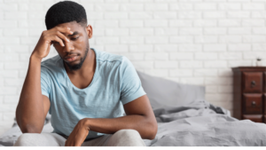 Close-up of a gay person holding their head in distress, symbolizing the struggles a person who suffers from benzo withdrawal.