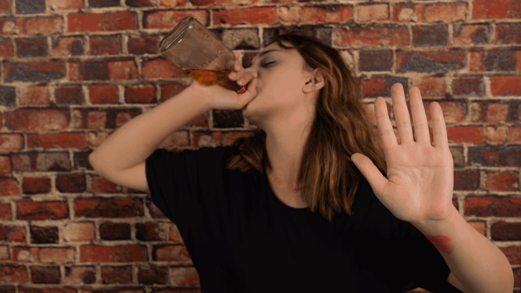 A transgender person drinking directly from a bottle of alcohol.